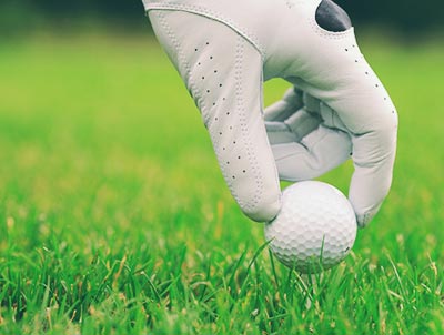 Team-building gant posant une balle de golf